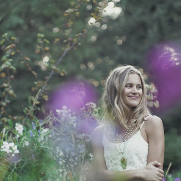 Natural light portrait of a young woman posing in a field of wildflowers